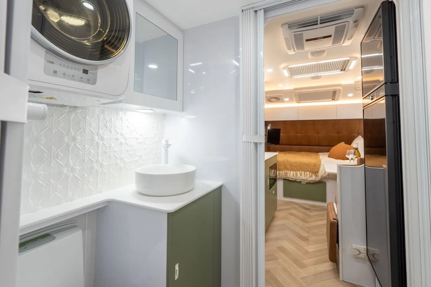 Wonderland RV bathroom with a washing machine, looking through to the lounge