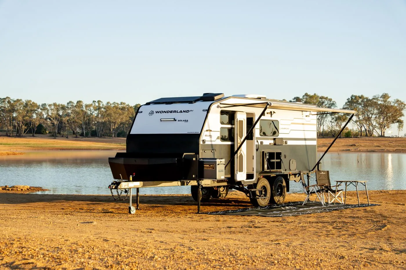 Wonderland RV Solara with camp chairs out on a lakeside beach