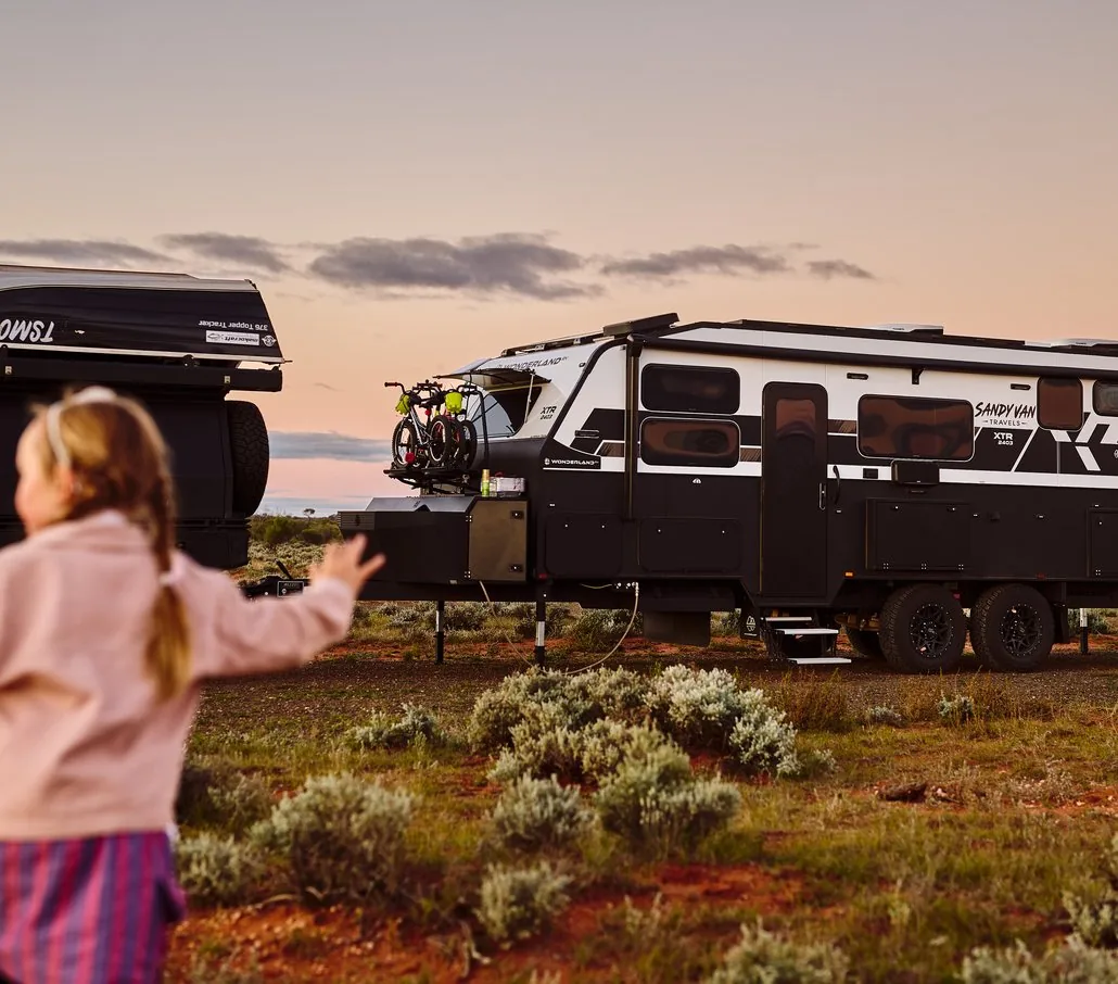 One of the Sandy Van Travels kids running towards the caravan at sunset