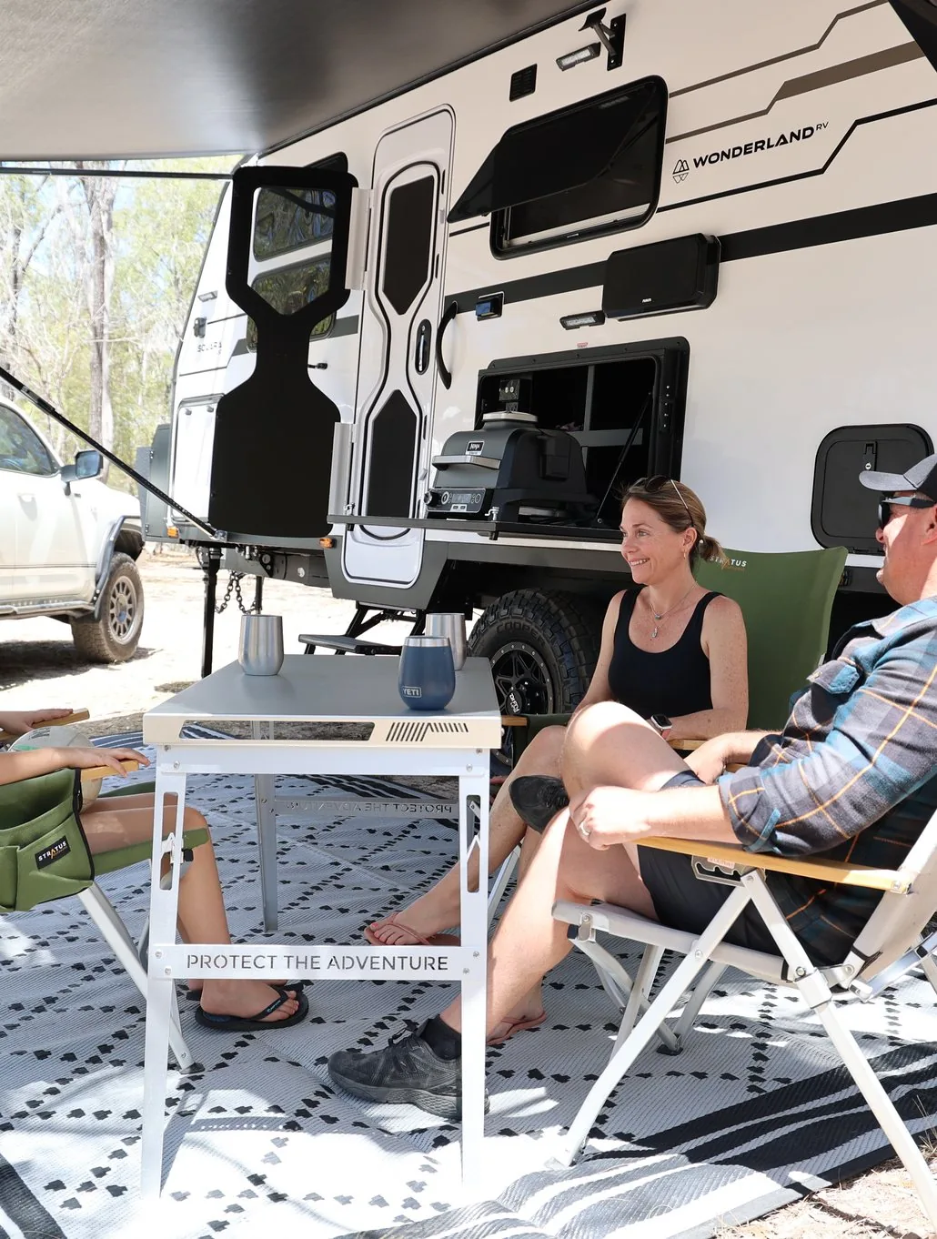 The Feel Good Family relaxing under the awning of their Wonderland RV Solara